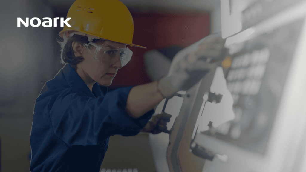 A person in a hard hat and safety goggles operates machinery tied into the industrial control system. The Noark logo is visible in the corner.