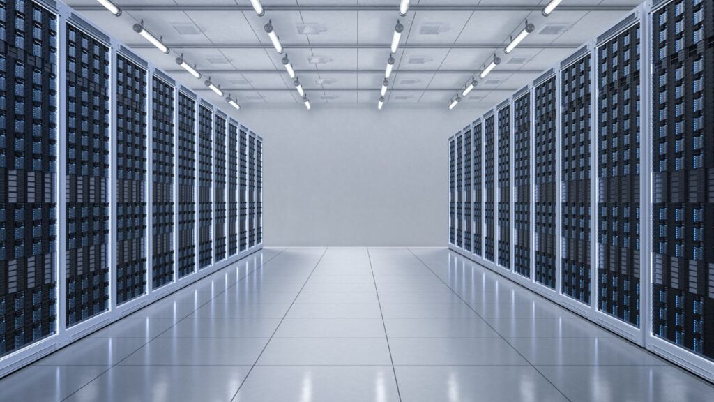 A modern data center with rows of server racks, optimized for digital storage, line both sides of a polished corridor under bright ceiling lights.