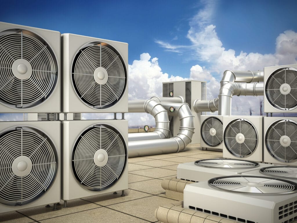 Rooftop view showcasing multiple HVAC units and ductwork under a blue sky with clouds, highlighting the intricacies of modern refrigeration systems.
