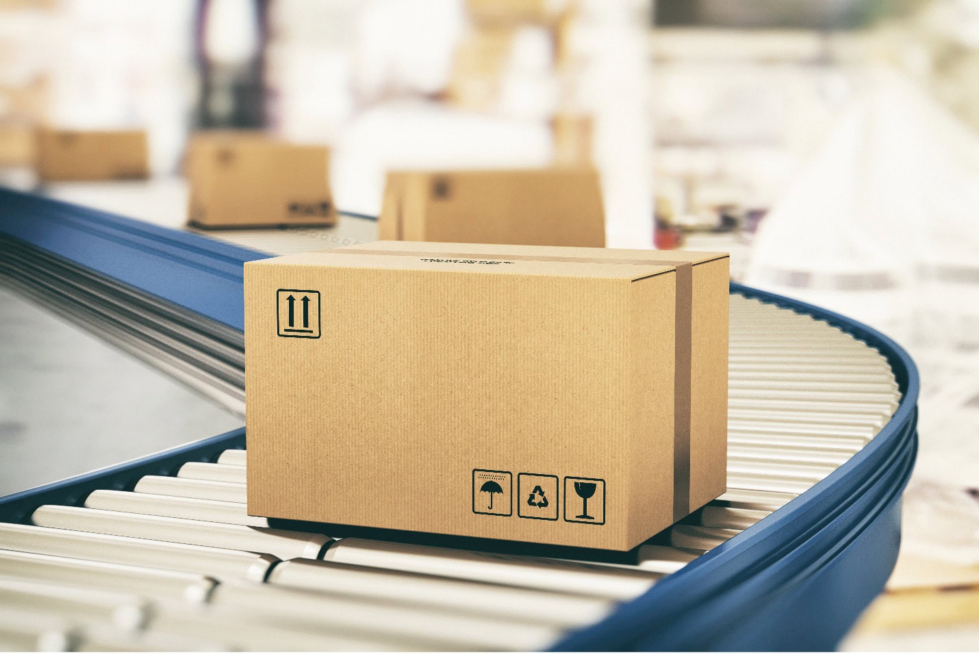 Cardboard box with symbols indicating fragile and recyclable, placed on a moving conveyor belt in a warehouse setting.