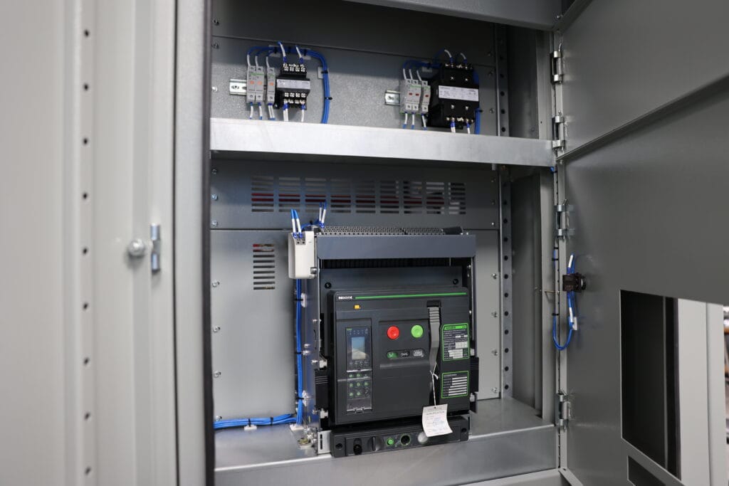 Inside the electrical panel, a network of wires, circuit breakers, and buttons intricately aligns with modern switchboards ensuring seamless functionality.